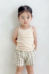 Girl wearing Avauma butter check set – sleeveless top with classic beige gingham shorts